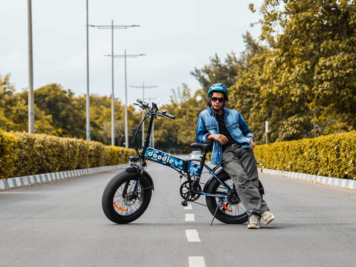 Rider leaning on an EMotorad Doodle folding electric cycle on an open road