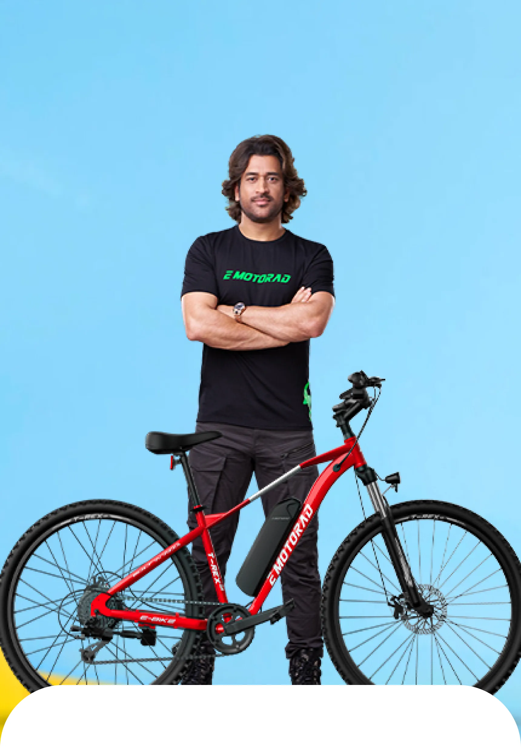 MS Dhoni standing beside a red EMotorad T-Rex electric cycle